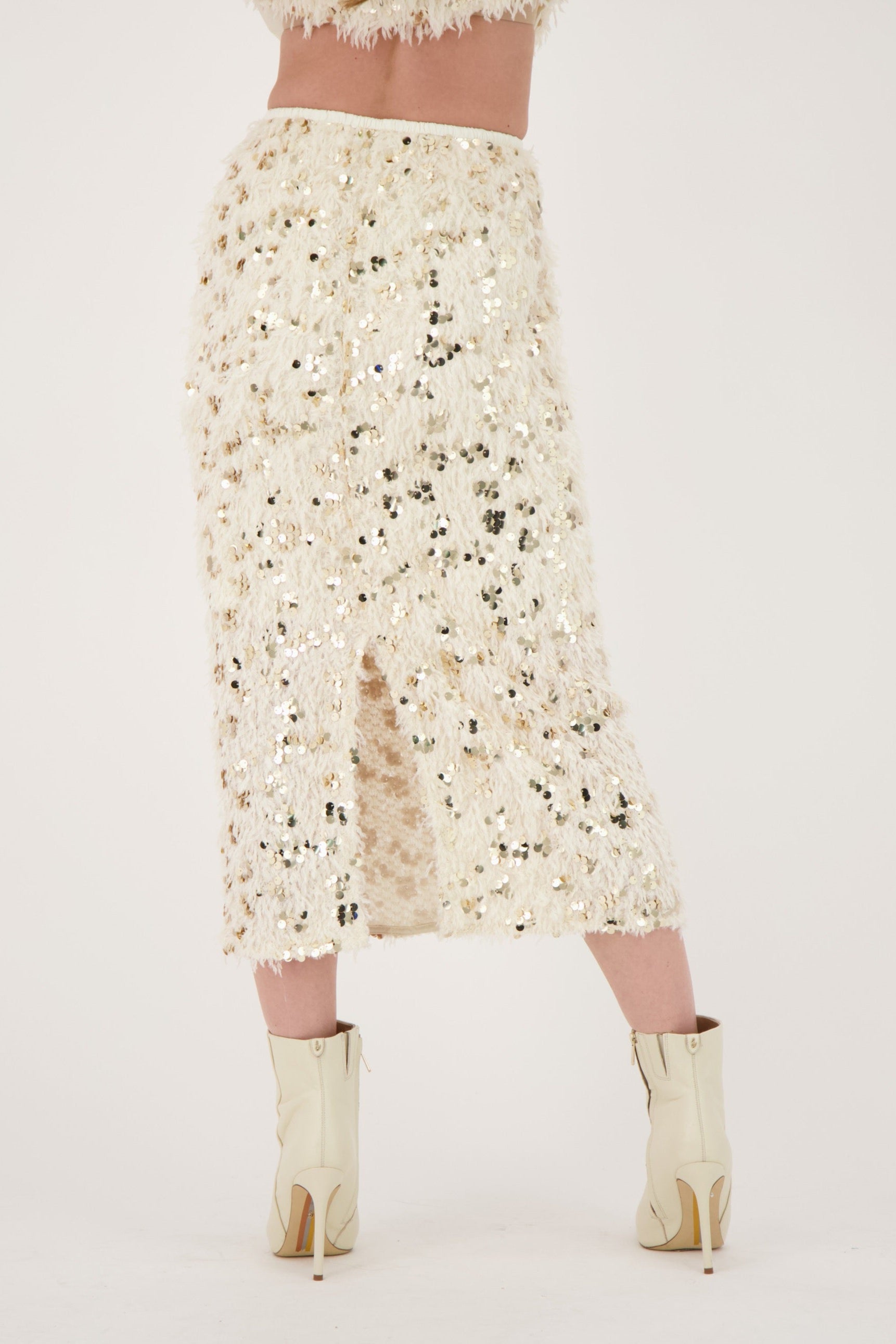 Person wearing a floral dress and gold boots on a white background