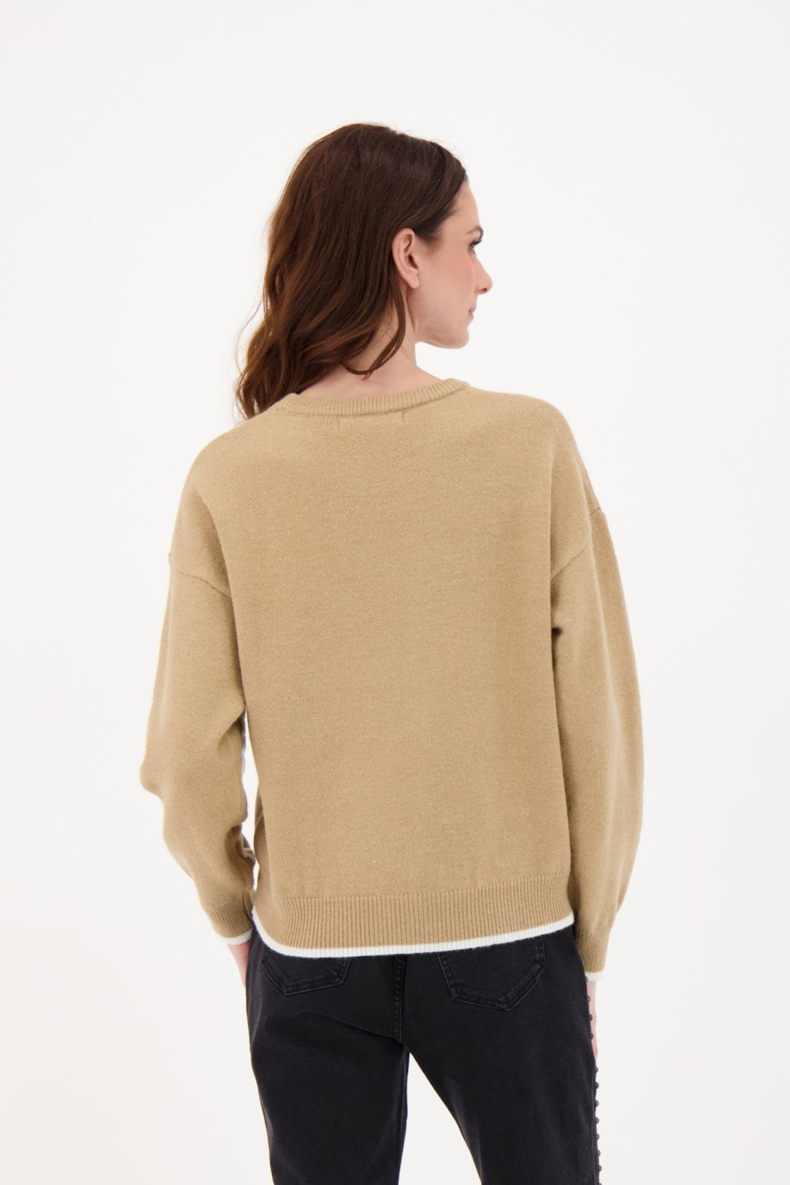Woman wearing a beige sweater on a white background