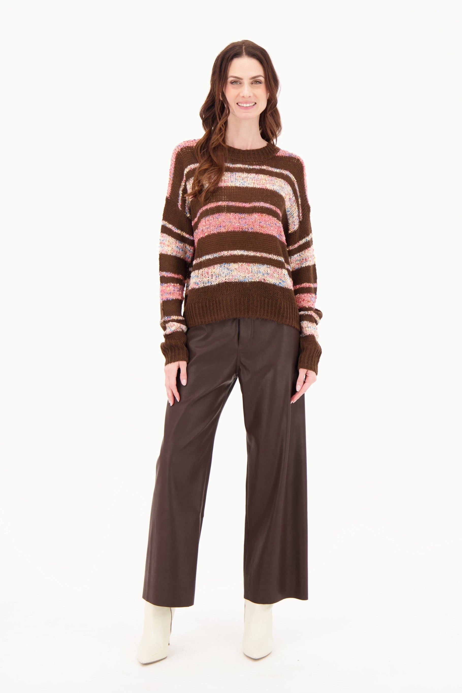 Woman wearing a striped sweater and brown pants on a white background