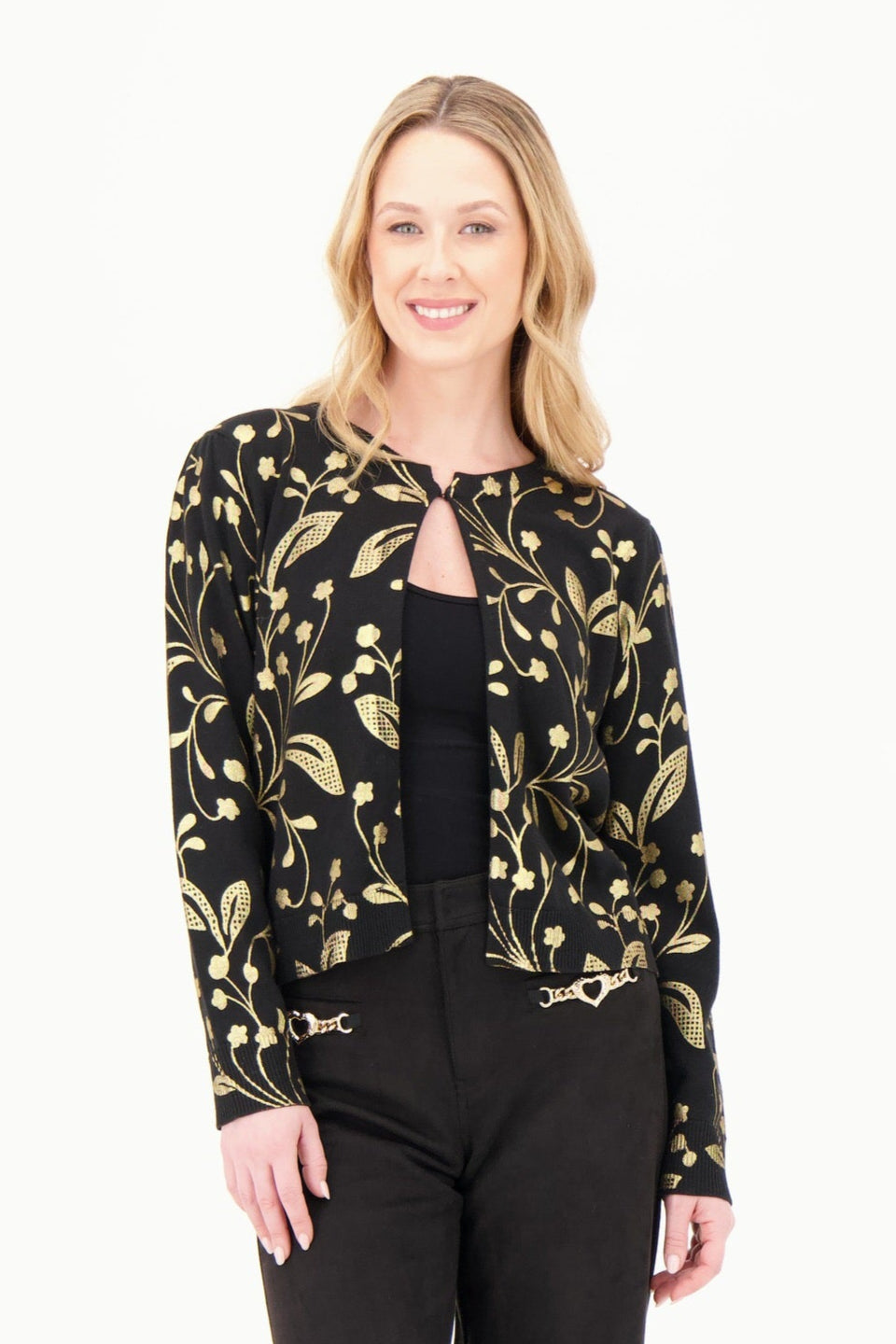 Woman wearing a black and gold patterned blouse with black pants on a white background