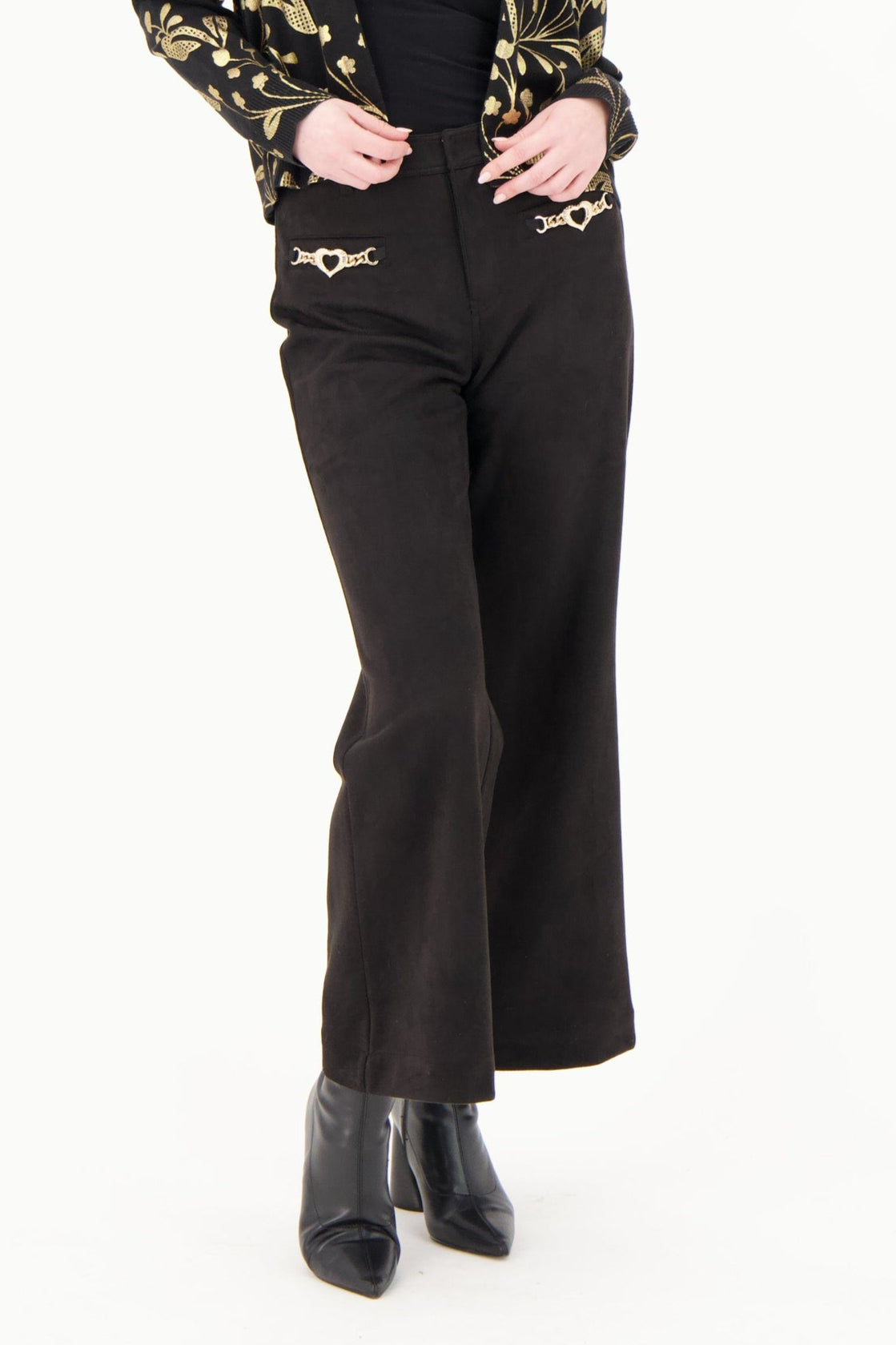 Woman wearing a black and gold patterned blouse with black pants on a white background
