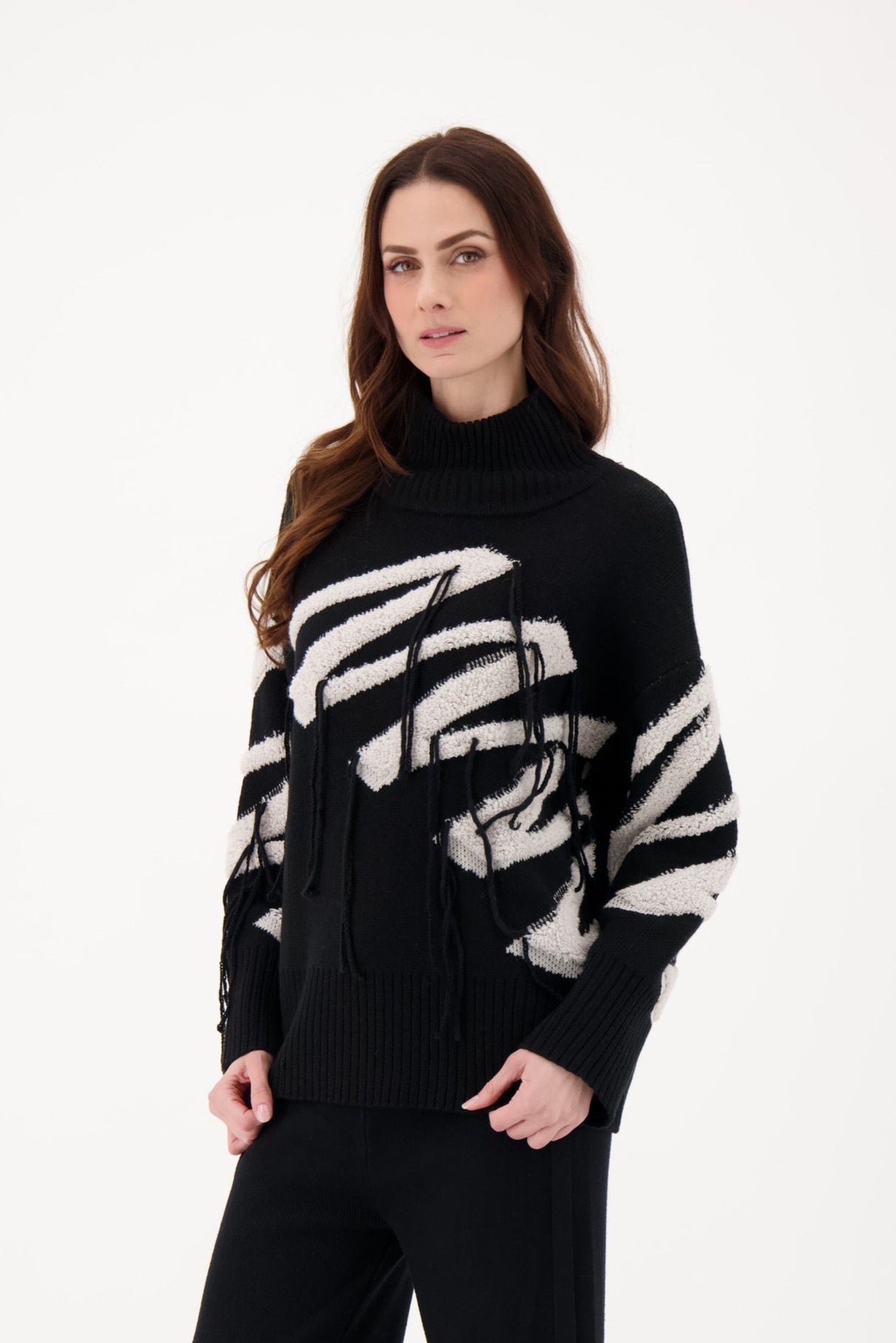 Woman wearing a black sweater with white pattern on a white background
