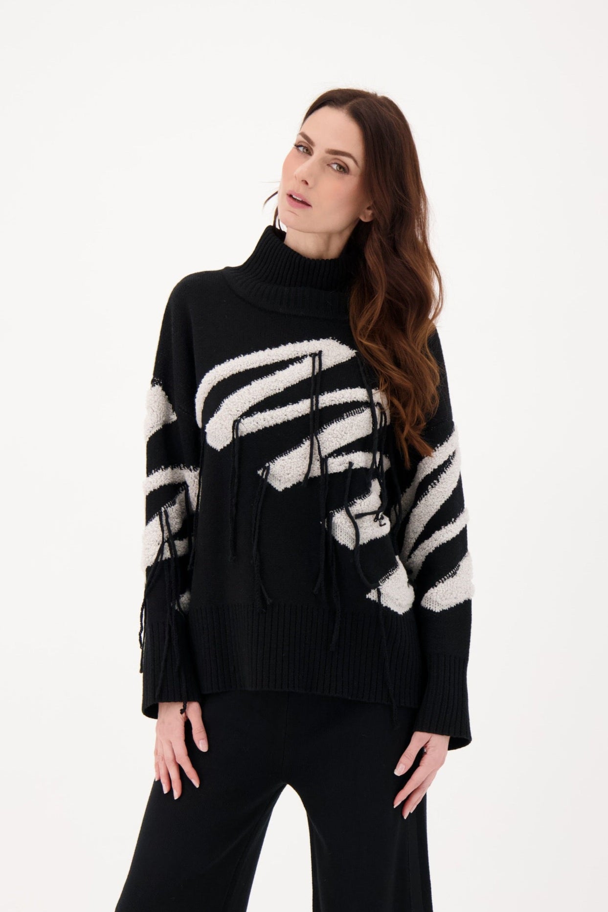 Woman wearing a black sweater with white pattern on a white background