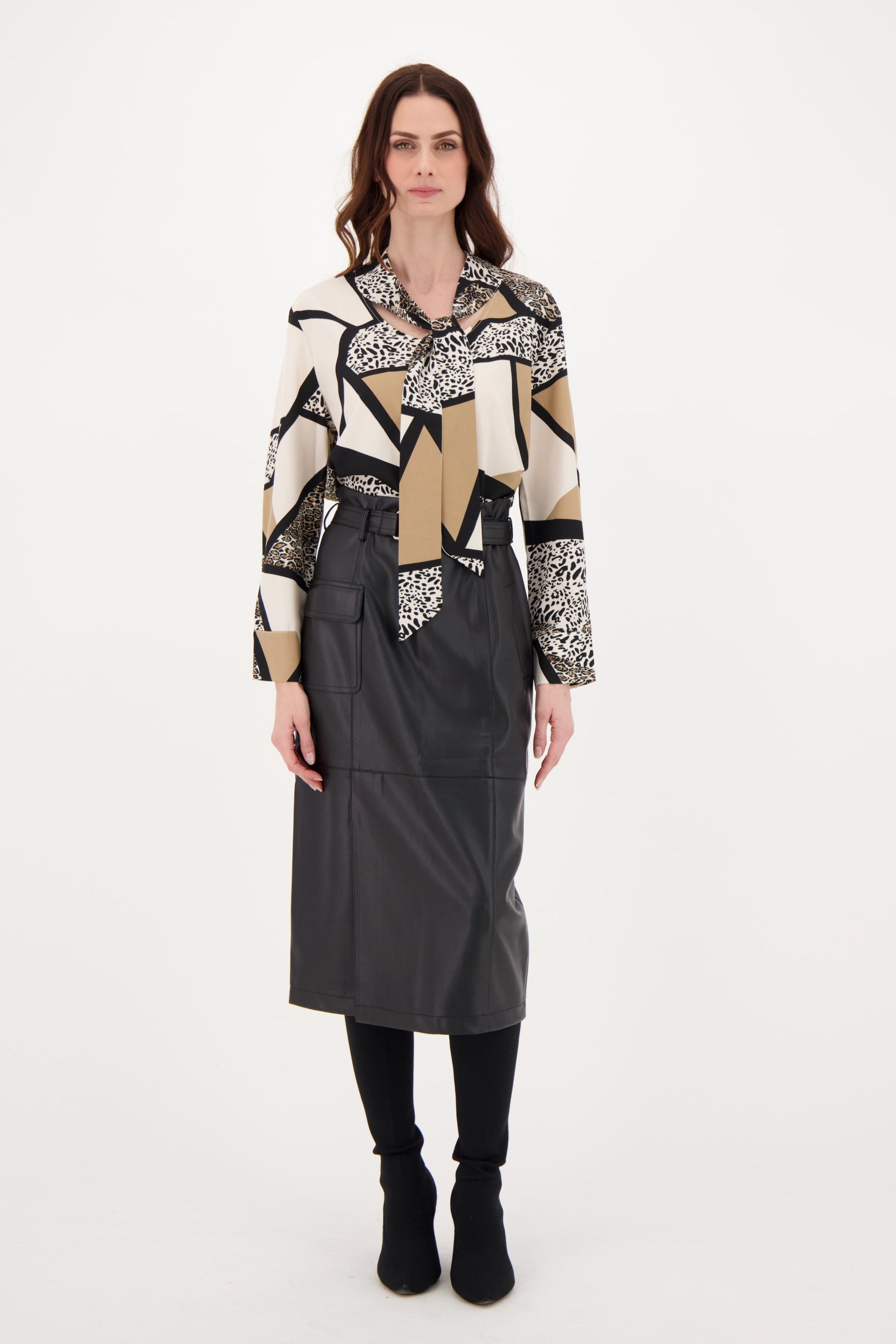 Woman wearing a patterned sweater and black skirt on a white background