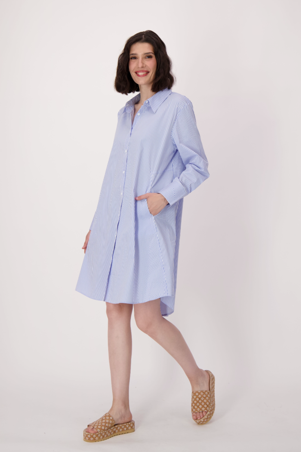 Woman wearing a light blue dress with a white background