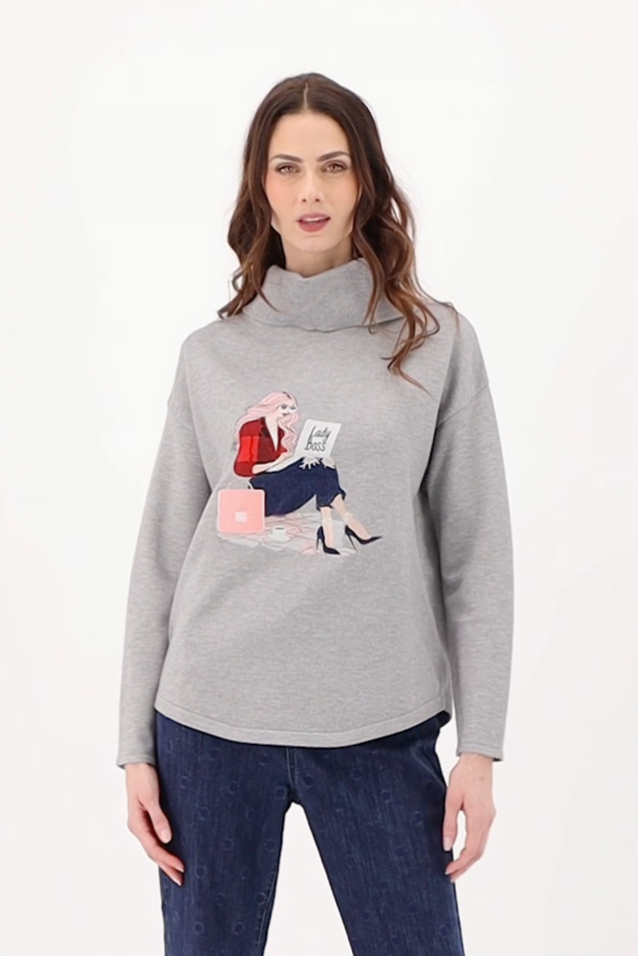Woman wearing a gray sweater with a graphic design on a white background