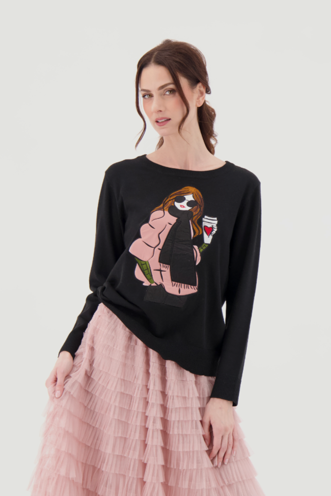 Woman wearing a black sweater with a dog design and a pink pleated skirt on a white background