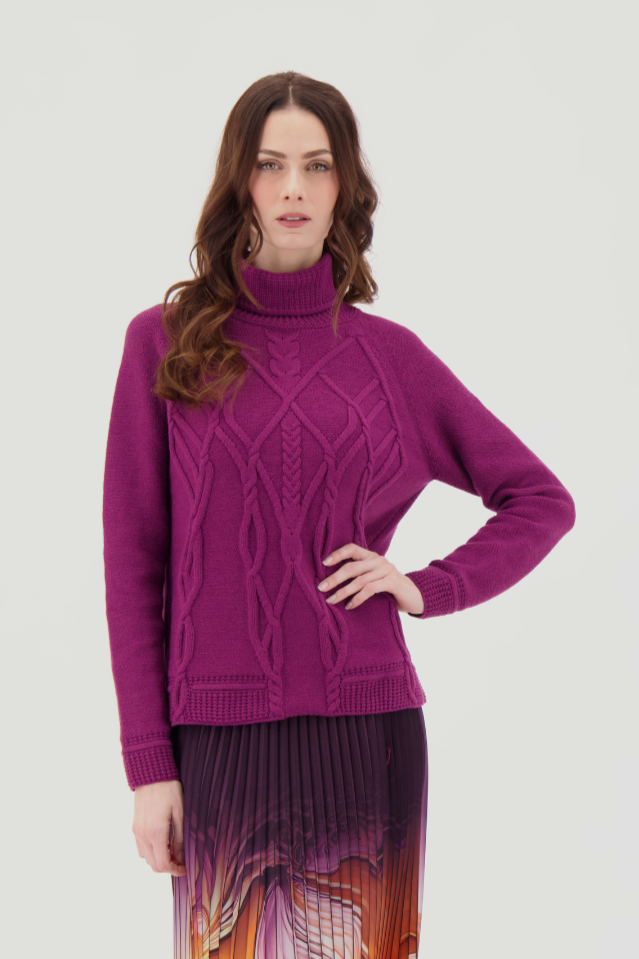 Woman wearing a purple sweater and patterned skirt on a white background