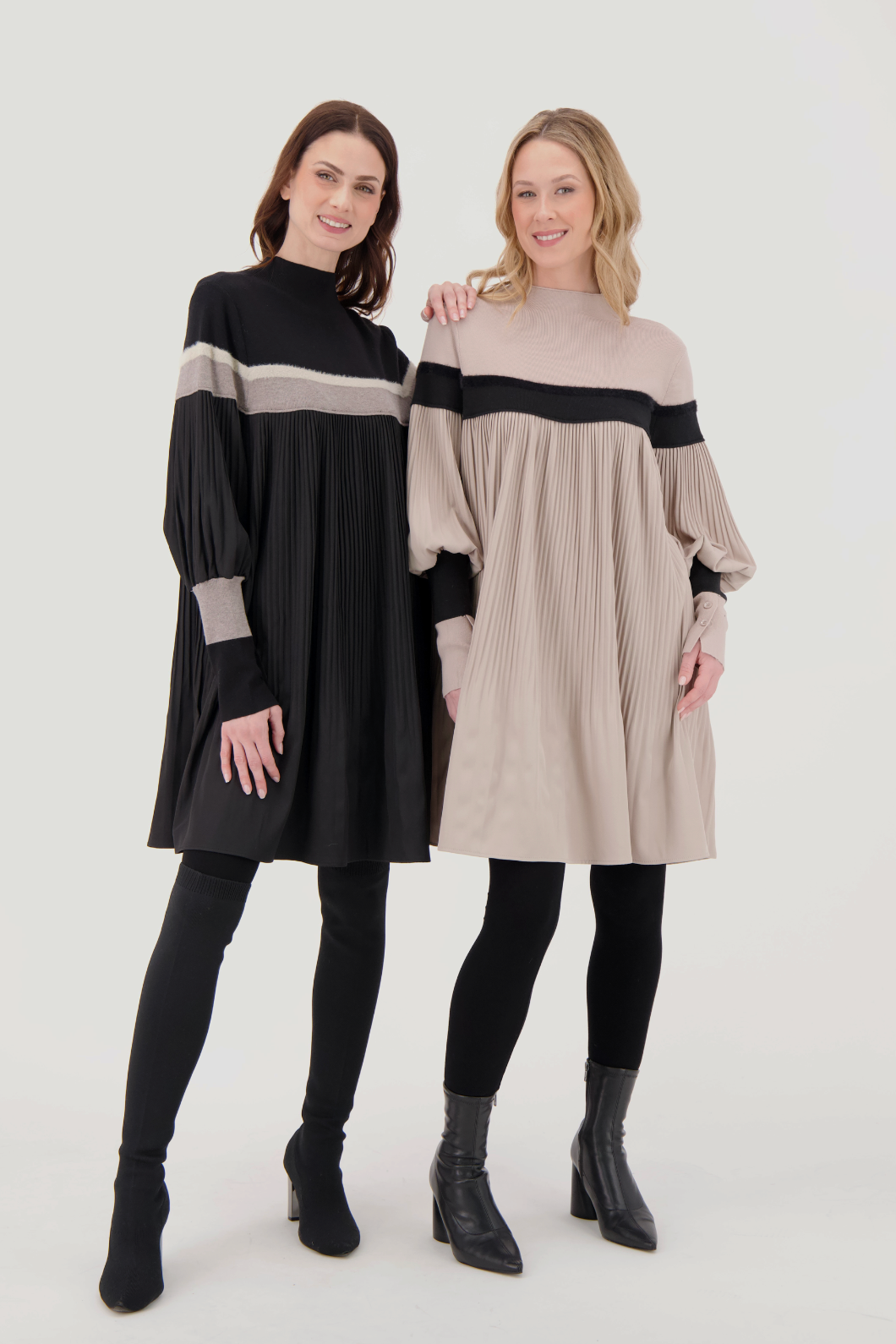 Two women wearing black and beige dresses on a white background