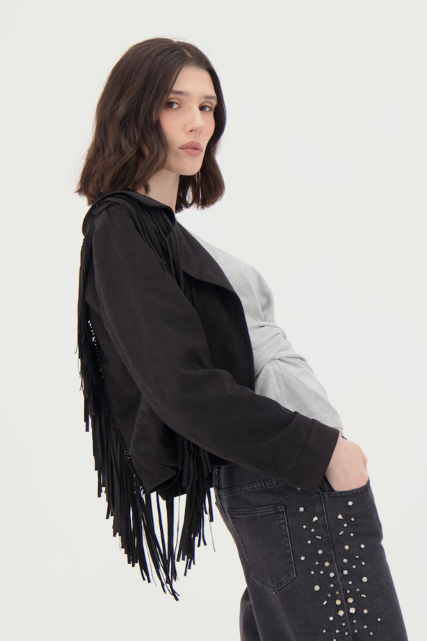 Woman wearing a black fringed jacket on a white background