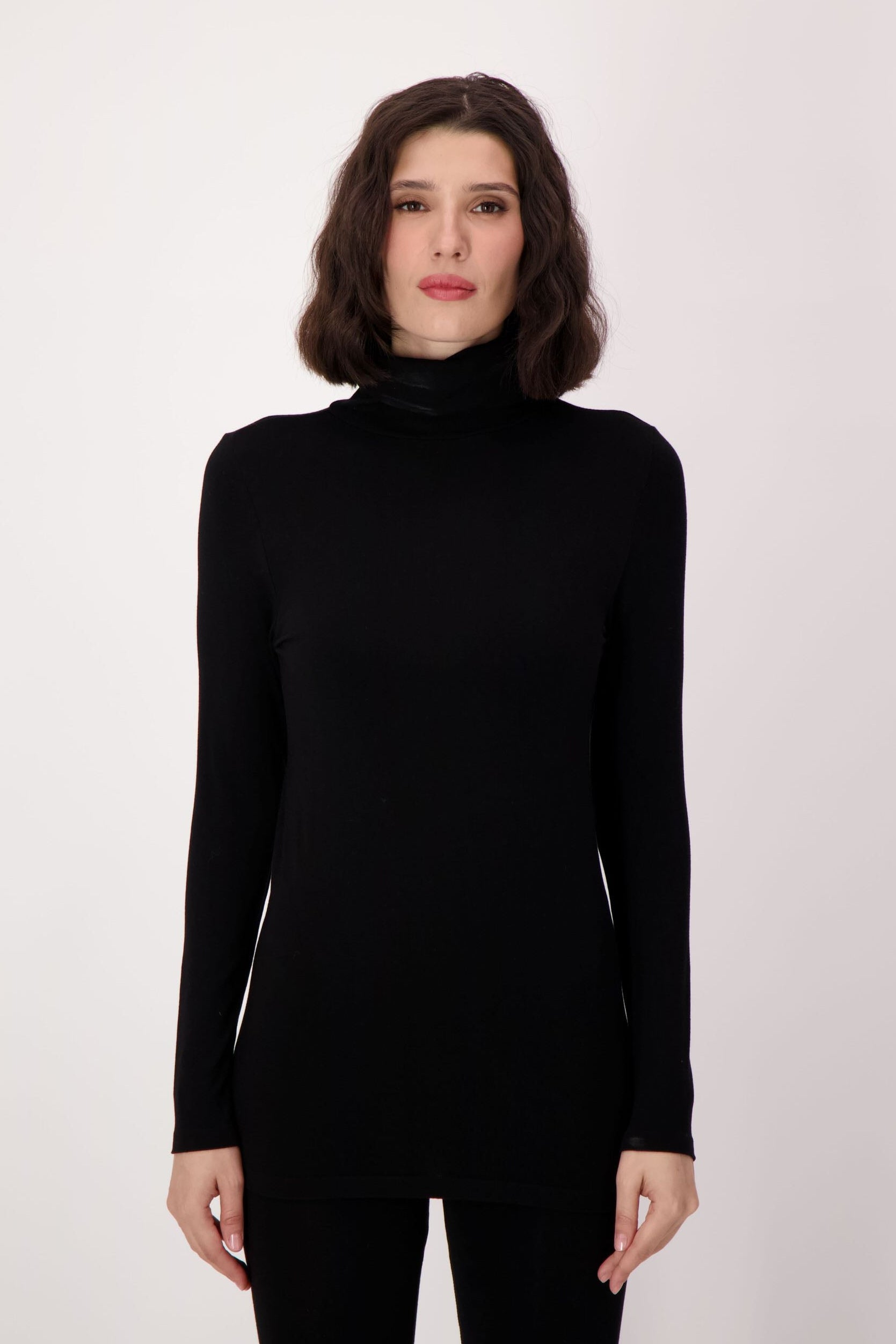 Woman wearing a black turtleneck sweater on a white background