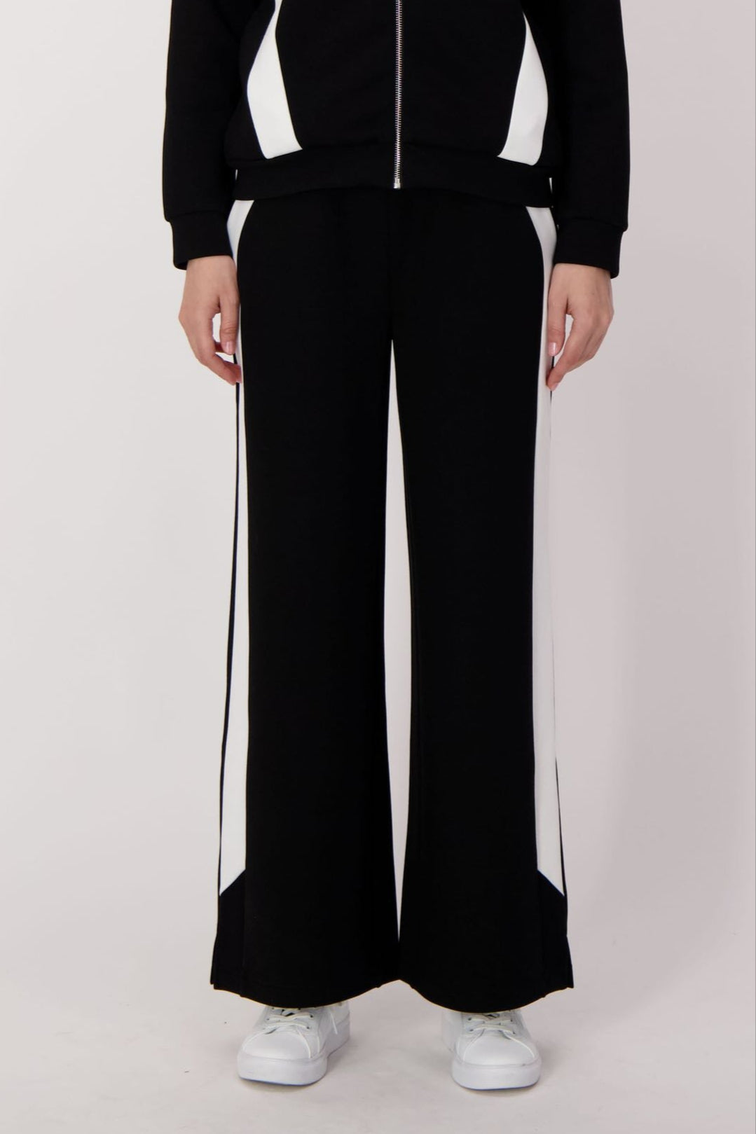 Person wearing a black and white tracksuit on a white background