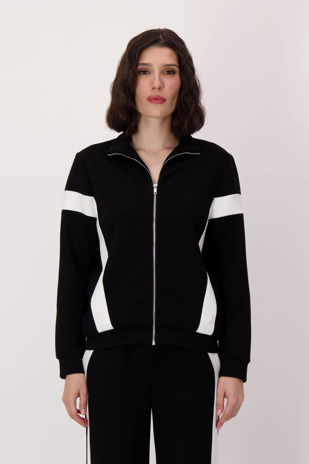 Person wearing a black and white tracksuit on a white background