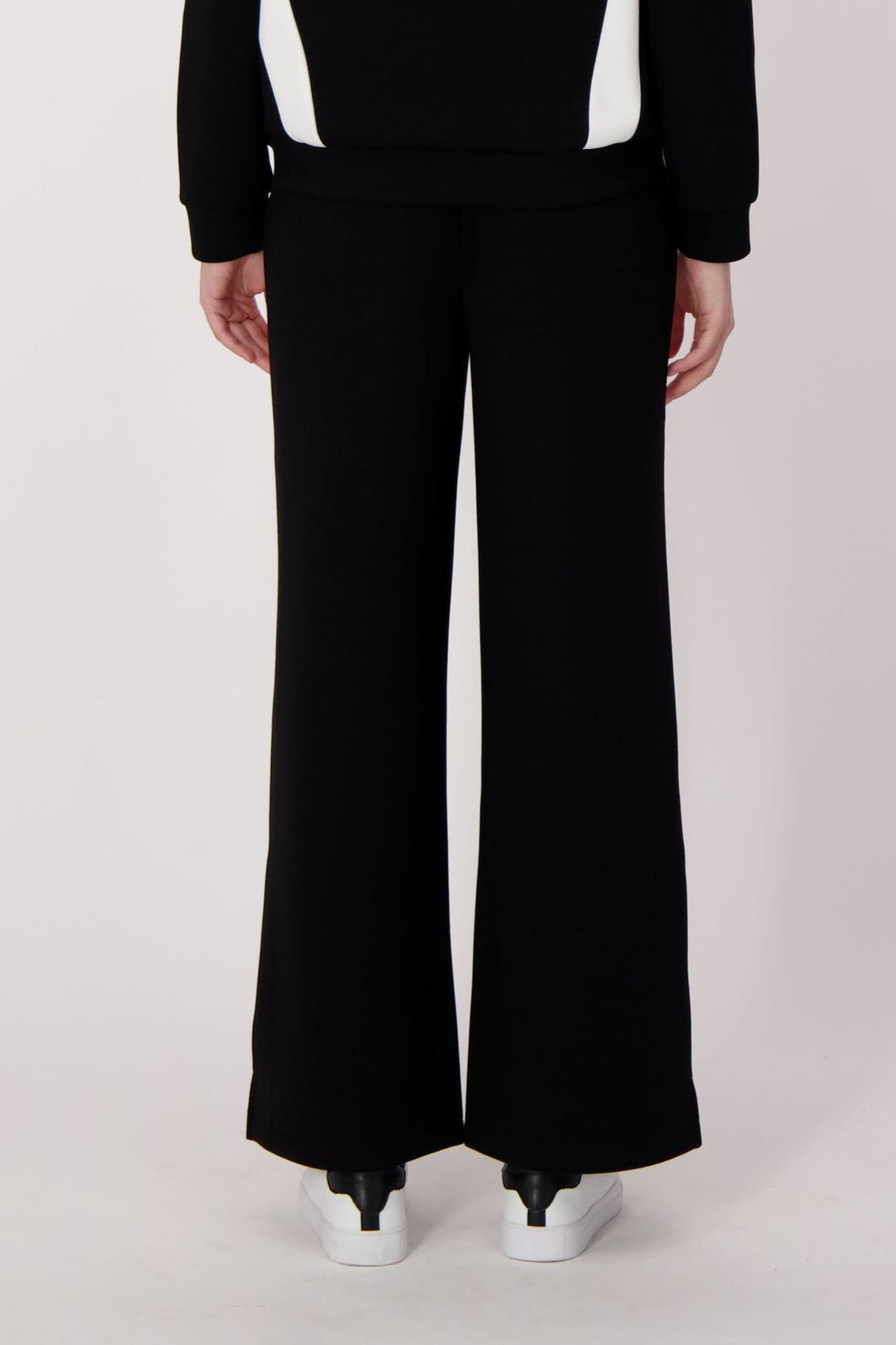 Person wearing a black outfit with white stripes on a white background